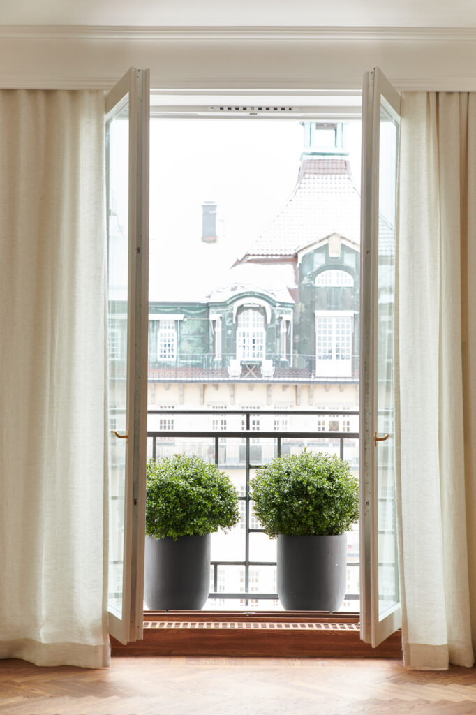 Bilden visar konstväxter i ett fönster. Med konstgjorda växter och konstgjorda blommor kan du enkelt skapa snyggare inredning hemma eller på jobbet.